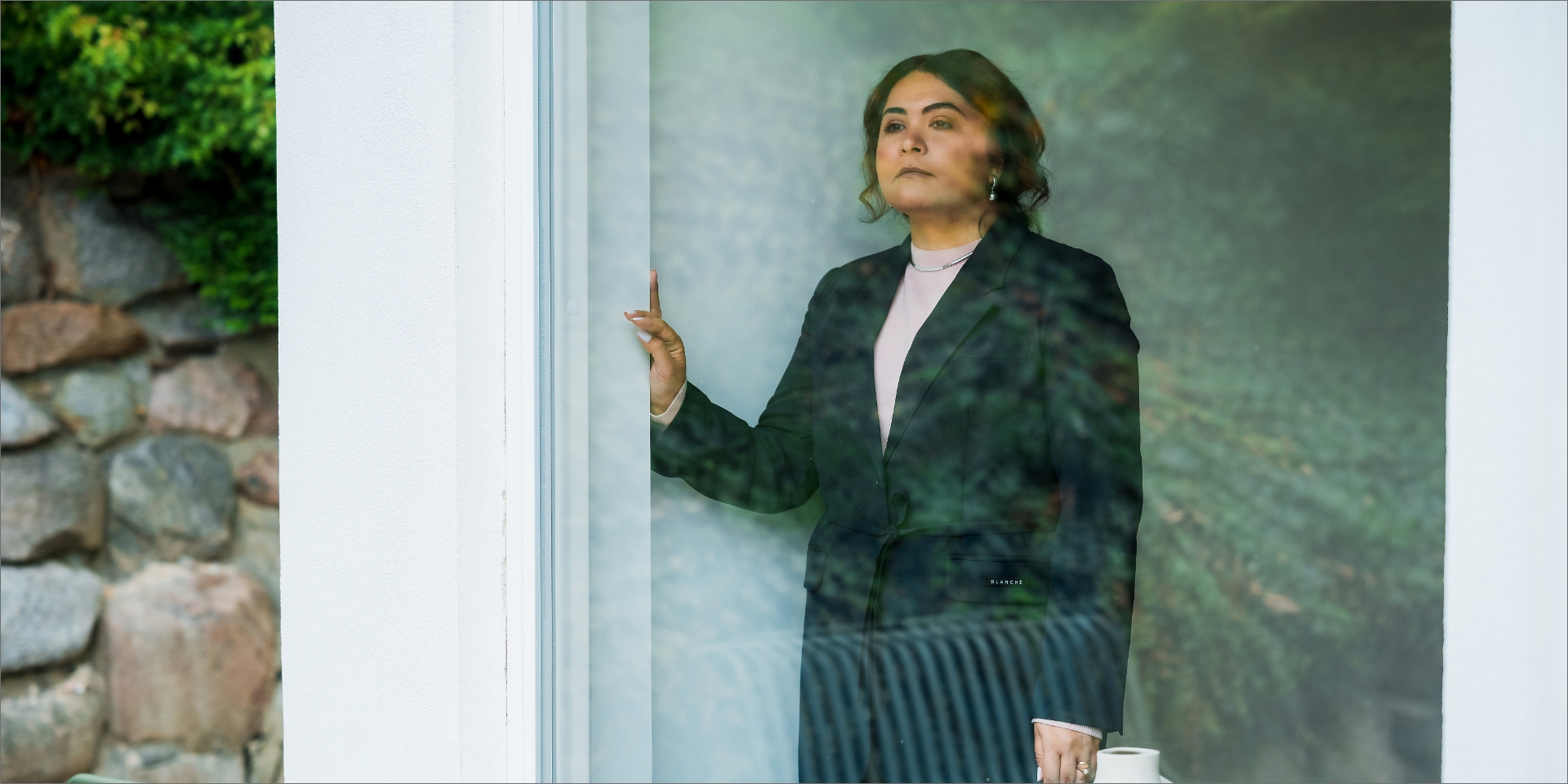 Aram Ostadian Binai står foran et vindue og kigger ud