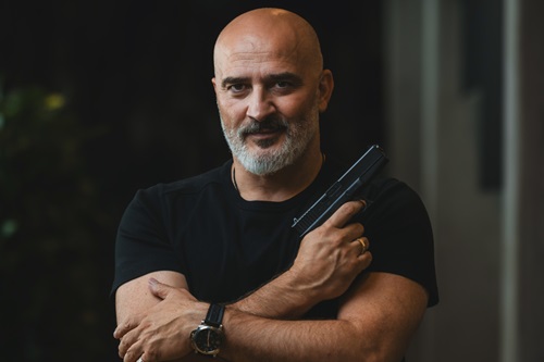 Hakan Abrak står med en pistol i hånden