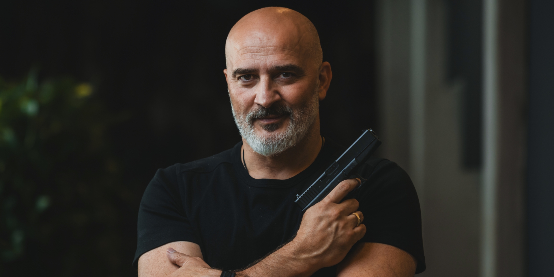 Hakan Abrak står med en pistol i hånden