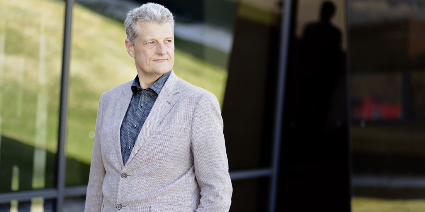Henrik Mogensen står med en hånd i sin lomme ude foran RTX bygningen