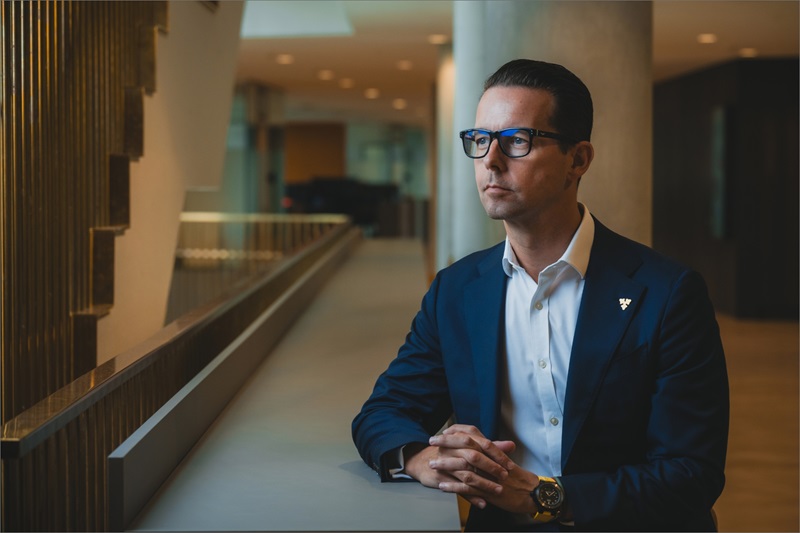 Jacob Aarup-Andersen står ved et bord og læner sig op ad det med sin ene arm på bordet