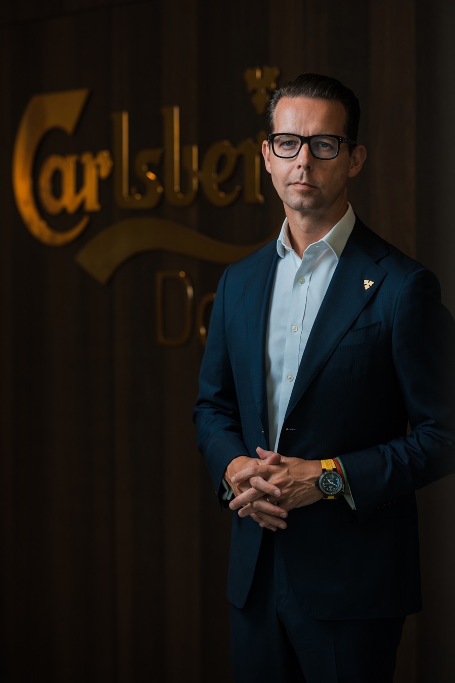 Jacob Aarup-Andersen står foran et Carlsberg logo på væggen i Carlsbergs hovedkontor