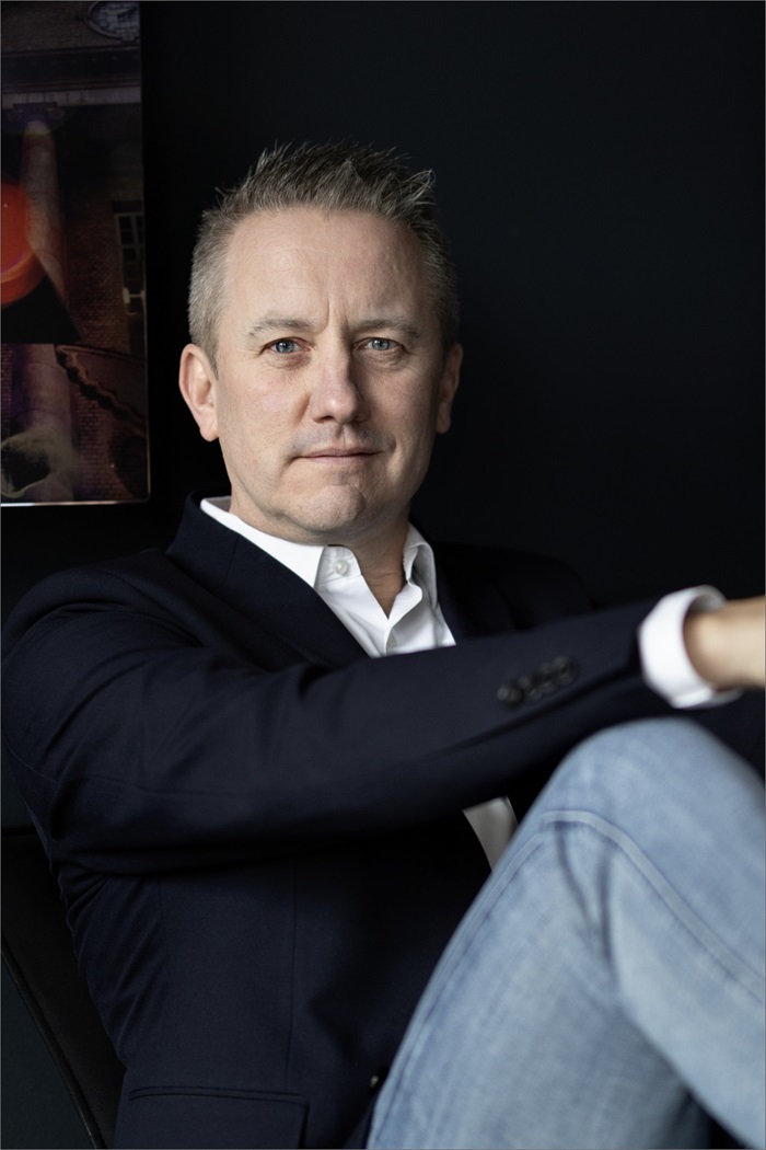 Jens Broch sidder lænet op ad en væg med foldet hænder