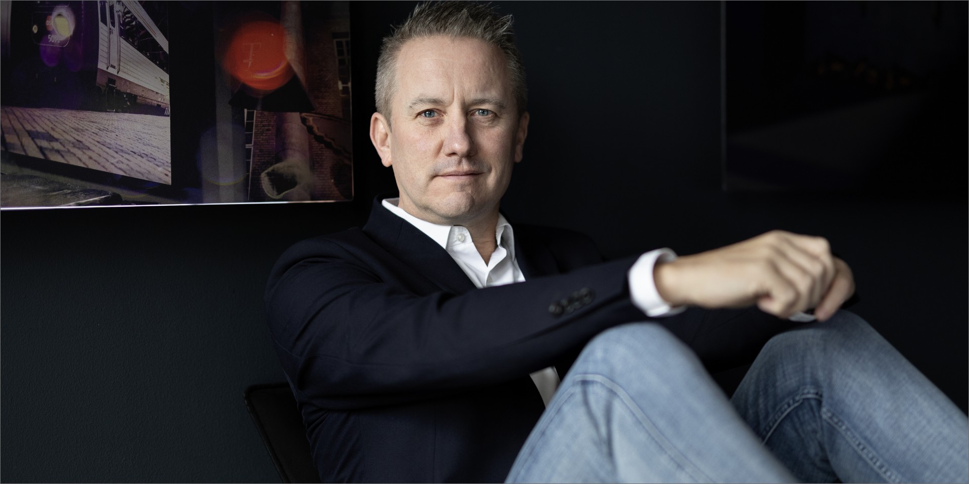 Jens Broch sidder lænet op ad en væg med foldet hænder