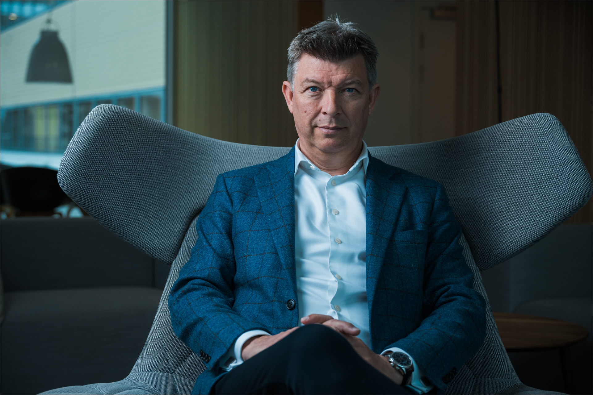 Kim Pedersen sidder i en grå lænestol