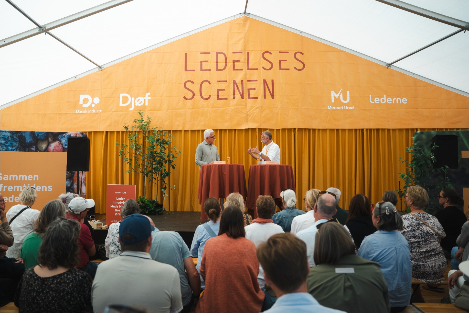 Mads Nipper står på Ledelses Scenen med chefredaktør Anders Hvass fra Lederstof.dk på Folkemødet 2025