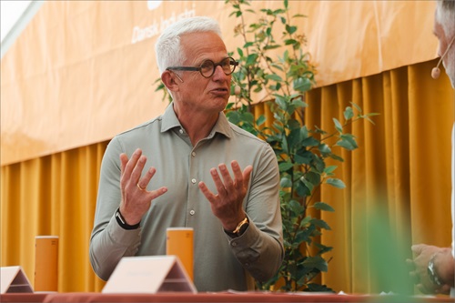 Mads Nipper står på Ledelses Scenen med chefredaktør Anders Hvass fra Lederstof.dk på Folkemødet 2025