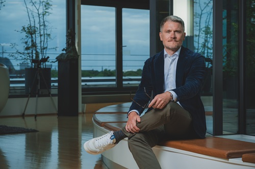 Martin Nyrop sidder på en bænk med krydsede ben
