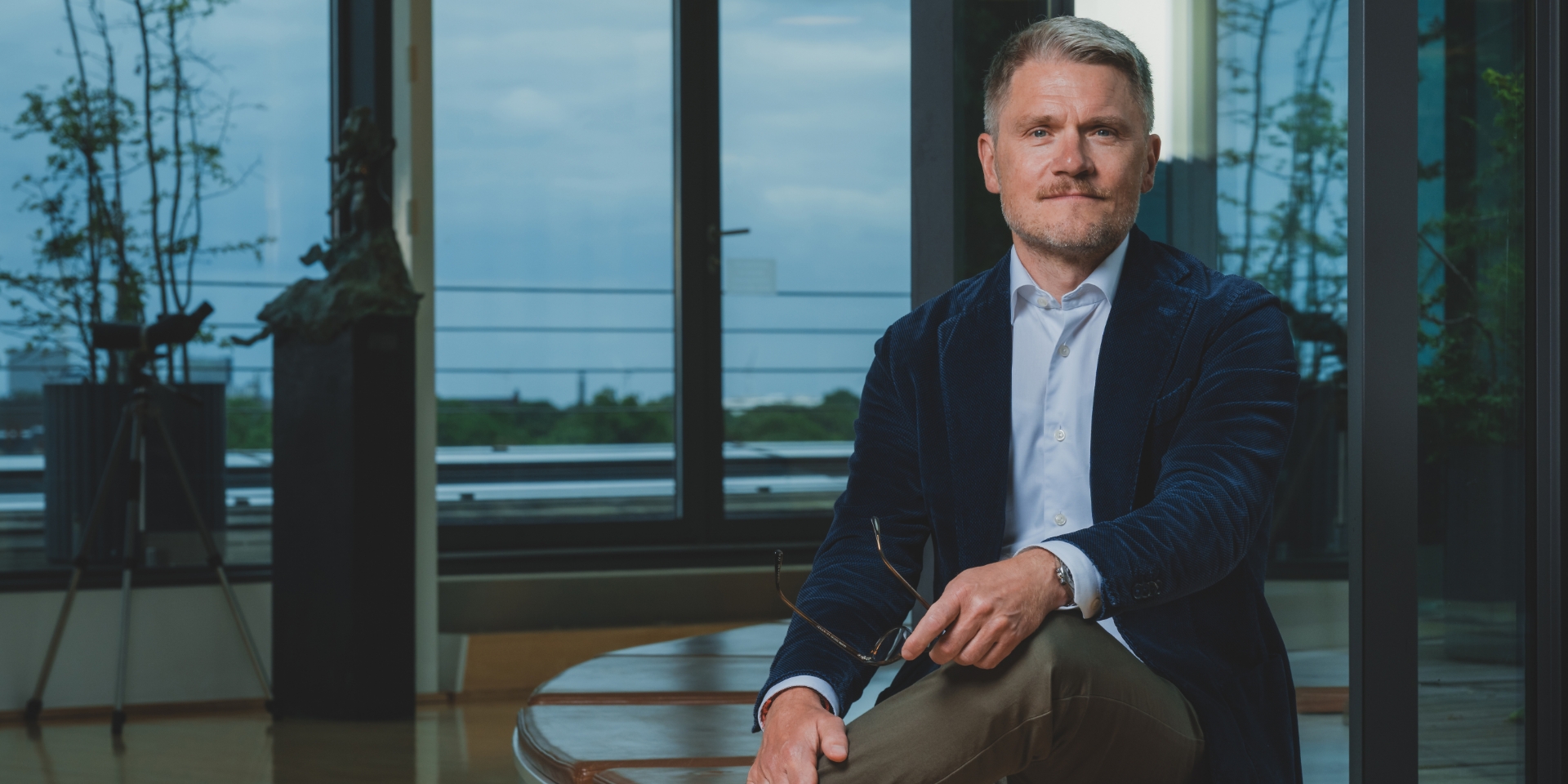 Martin Nyrop sidder på en bænk med krydsede ben