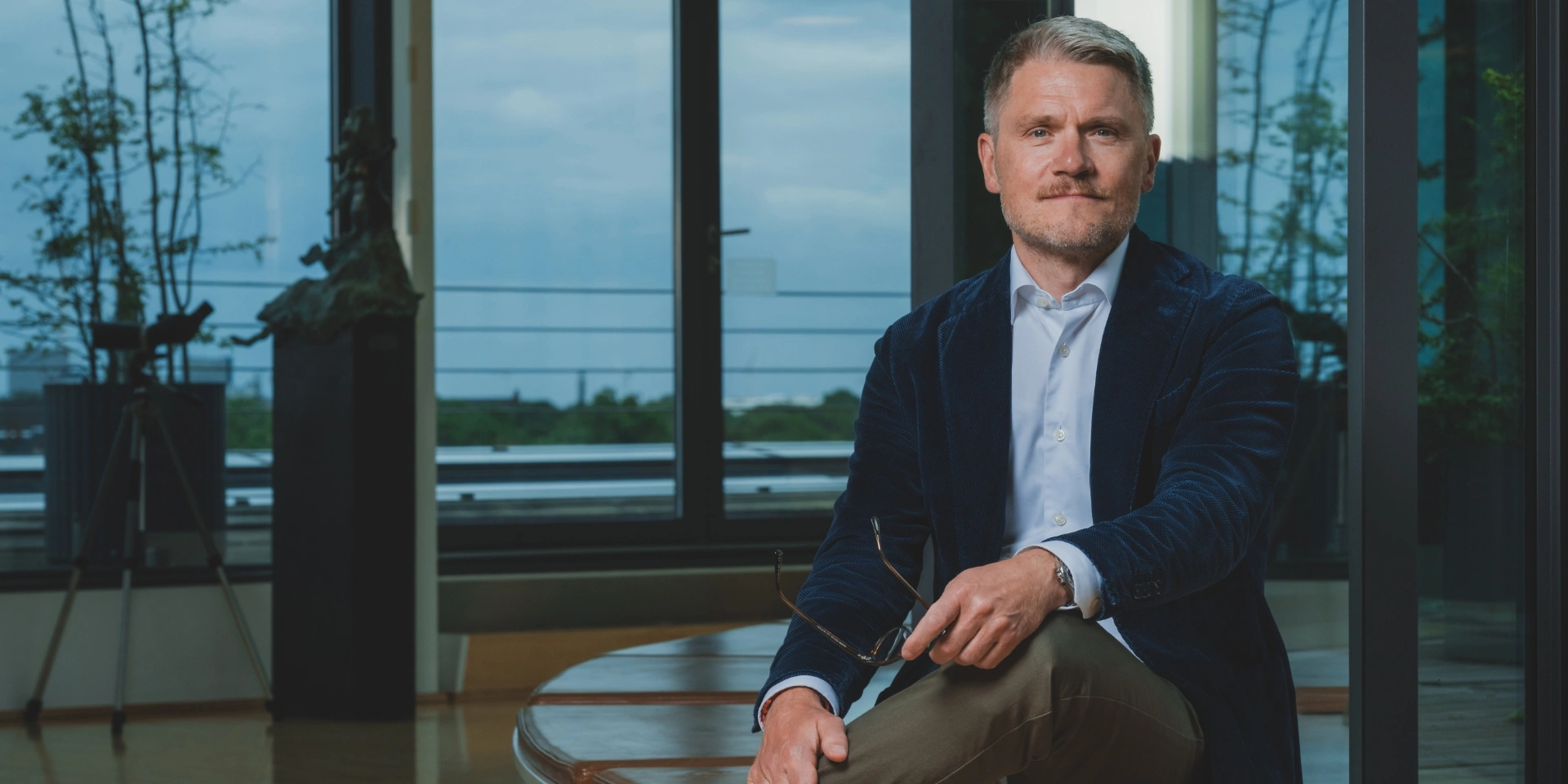 Martin Nyrop sidder på en bænk med krydsede ben
