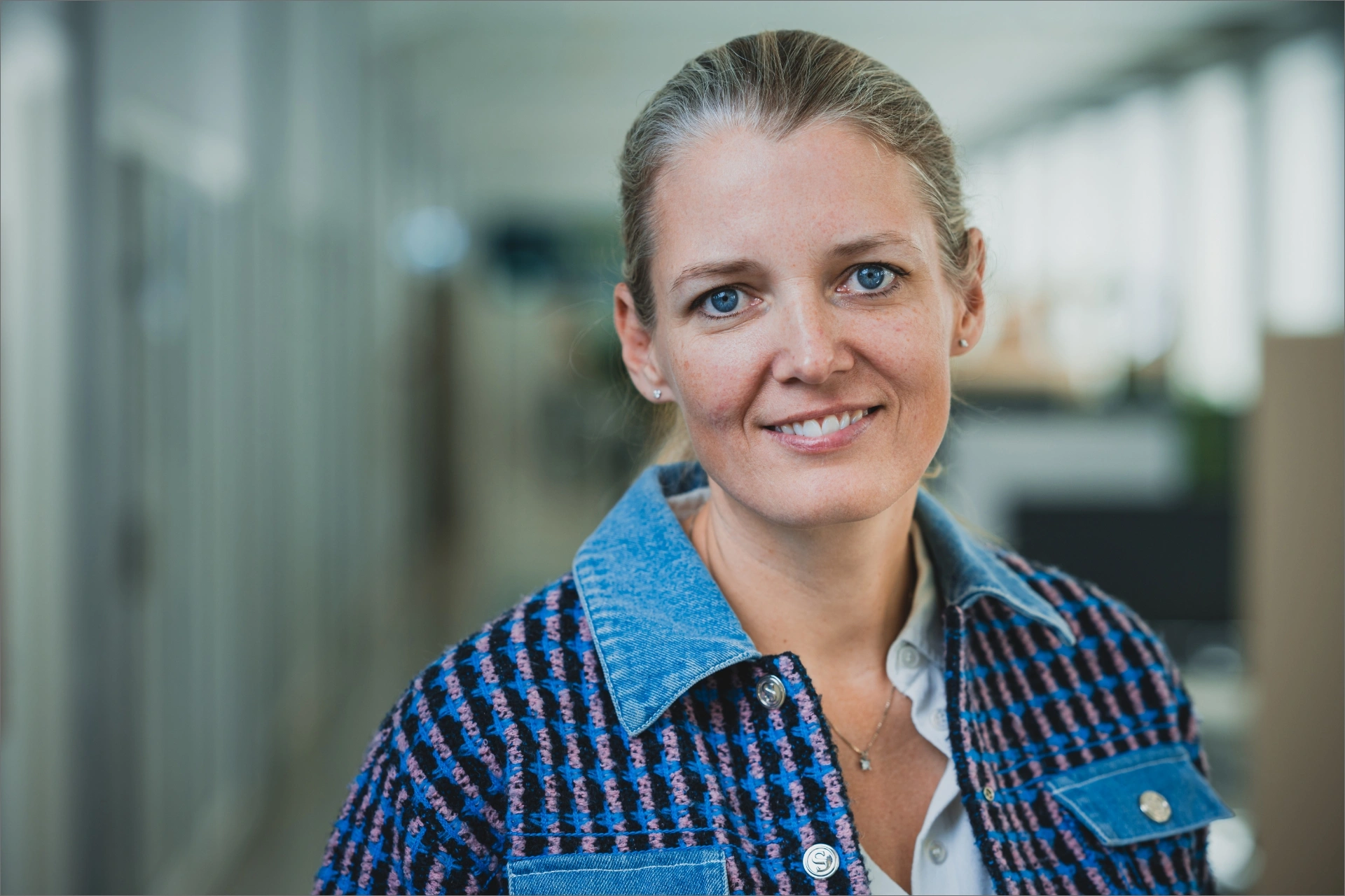 Mette Lykke smiler og er iført en blåstribet skjorte