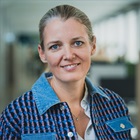 Mette Lykke smiler og er iført en blåstribet skjorte