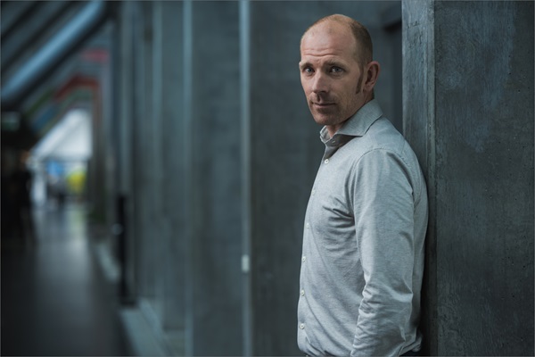 Michael Mørkøv står med ryggen lænet op ad en væg