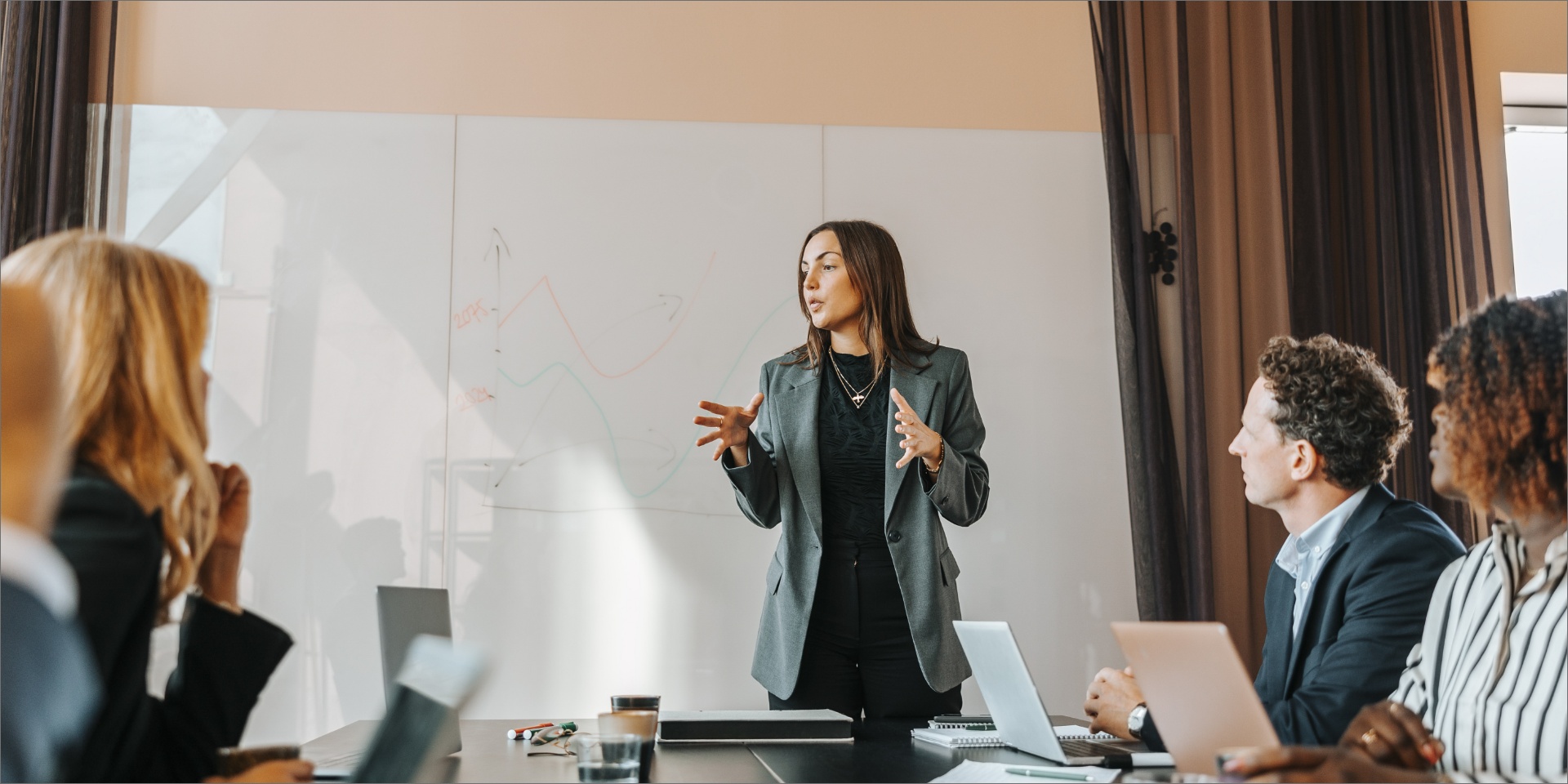 En kvinde står foran sine kolleger og præsenterer