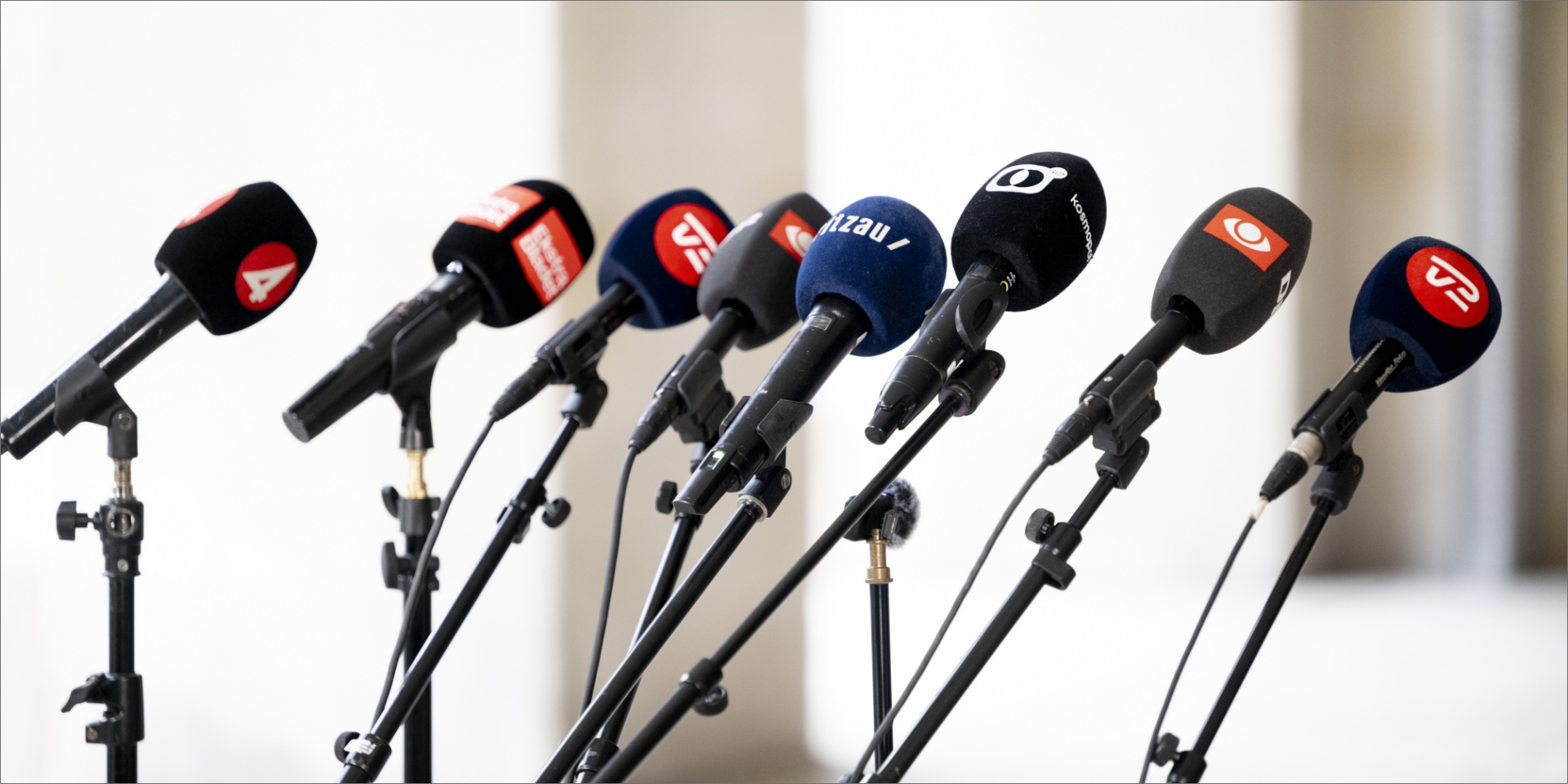 En række store mediehuses mikrofoner, DR, 4, Ekstrabladet, TV2, Kosmopol, Ritzau, er sat op på række