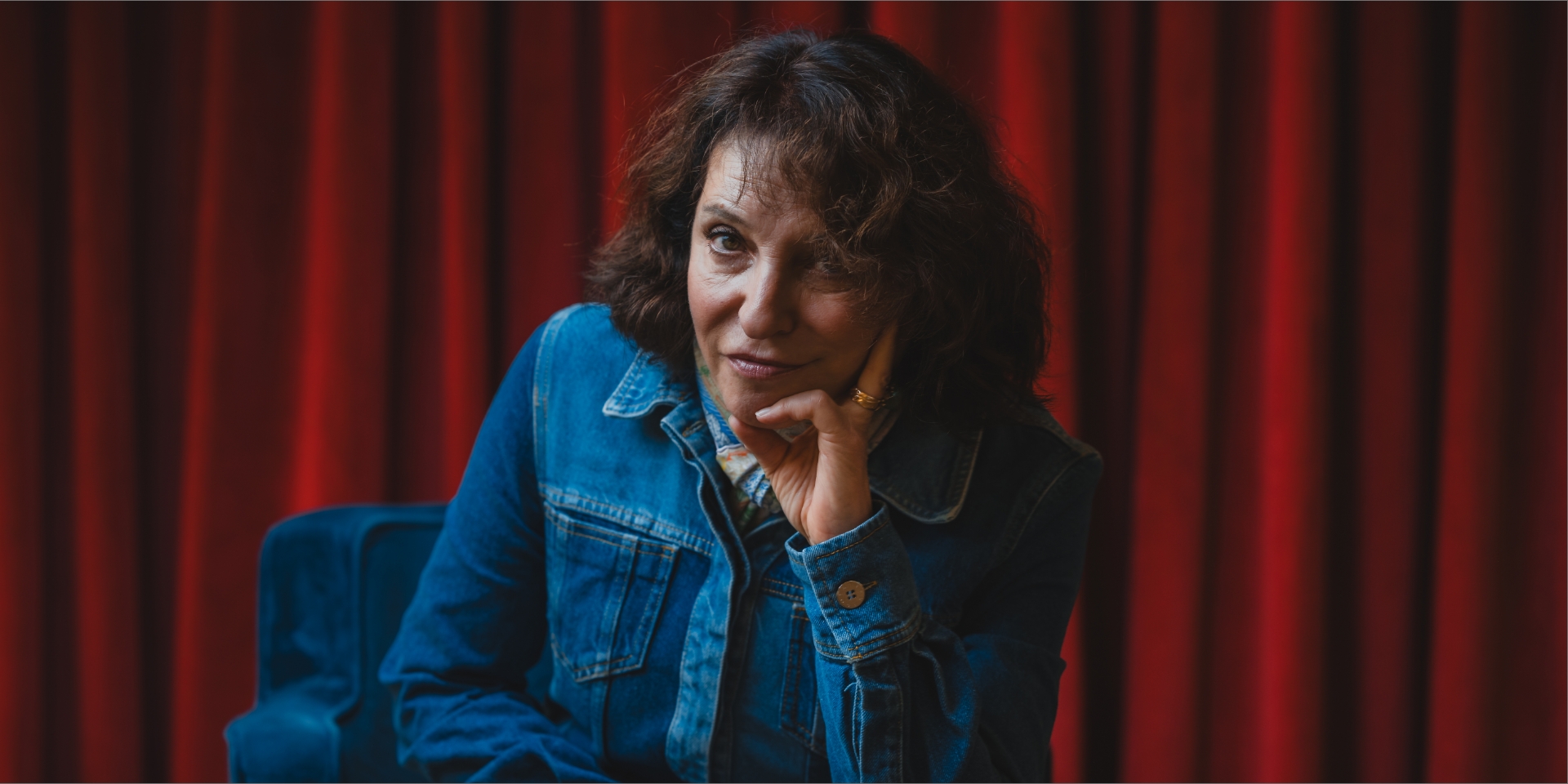 Susanne Bier sidder foran et rødt tæppe