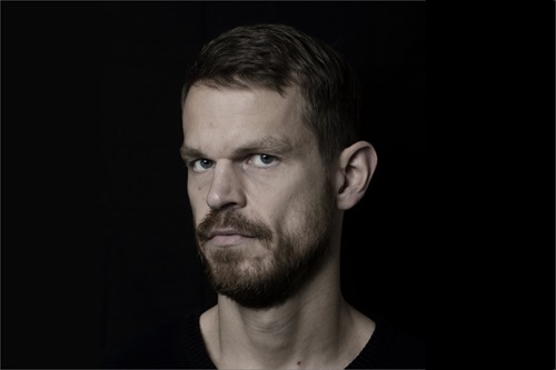 Svend Brinkmann står foran en sort baggrund i sort t-shirt