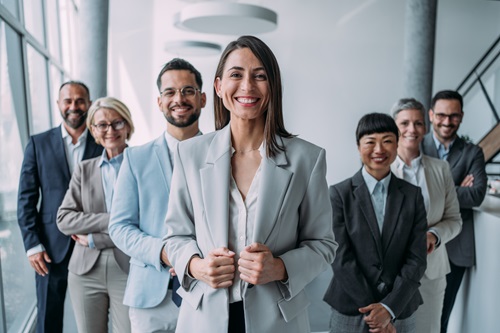 En kvinde står foran en række mennesker og smiler