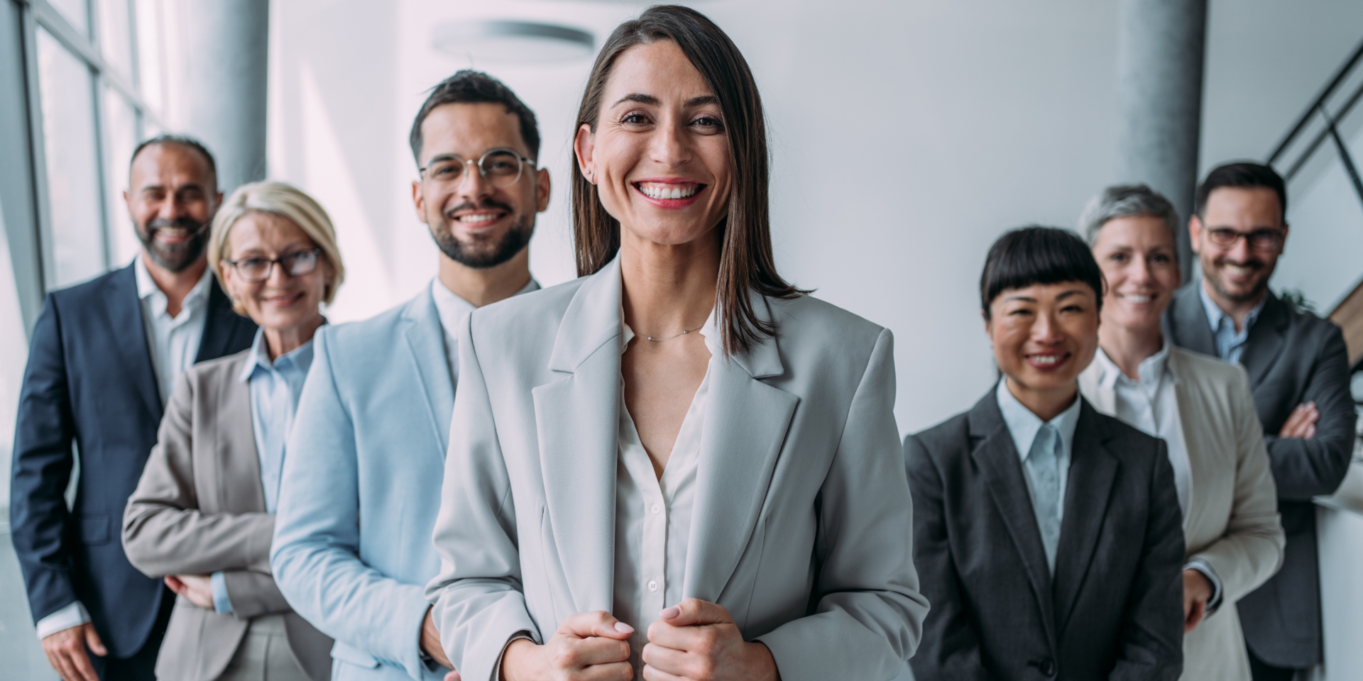 En kvinde står foran en række mennesker og smiler