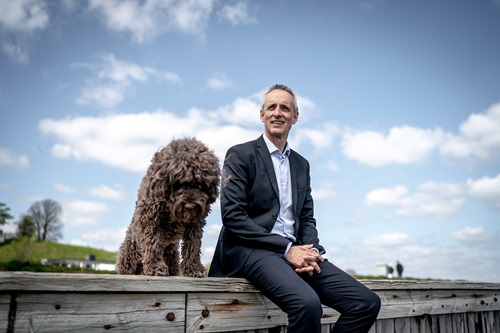 Anders Dons sidder ved vandet med sin hund