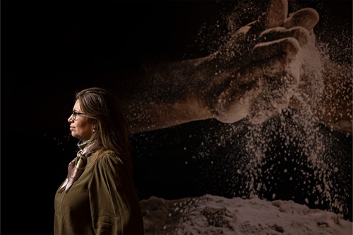 Anette Kalle står foran stor plakatbaggrund med bagerhænder