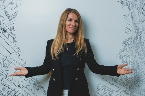 Bianca Bruhn står med spredte arme foran hvid væg