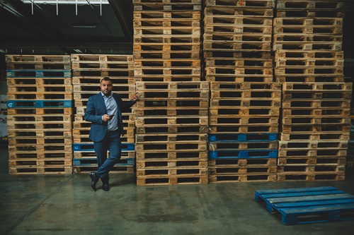 Braw Bakir på et Netto lager ved siden af en bunke paller