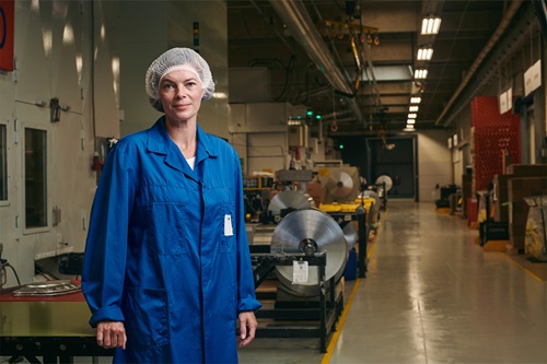 Camilla Haustrup Hermansen iført blå kittel på Plus Pack fabrikken