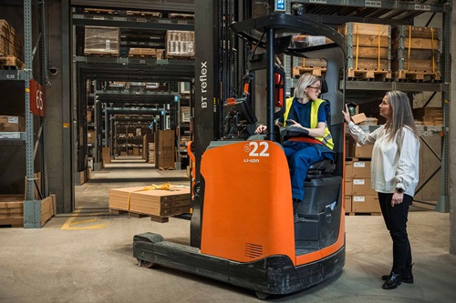 Charlotte Jensen står og snakker med en kvindelig gaffeltruckfører i IKEAs varelager