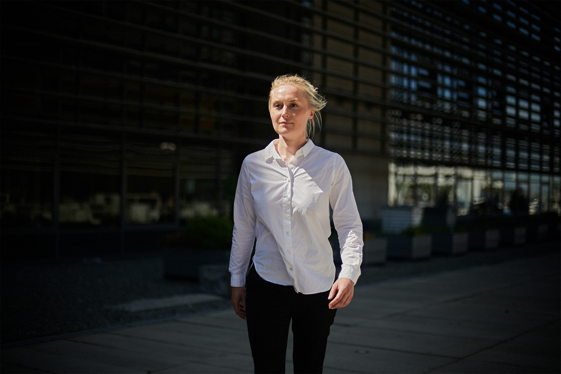 Christel Teglers går mod kameraret foran en bygning 