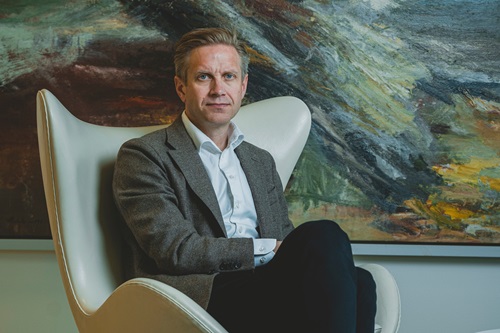 Portrætbillede af Christian Jensby foran et maleri