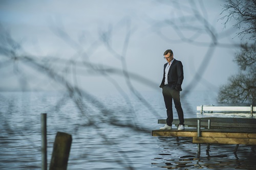 Eske Gunge står på en badebro og ser ned i vandet