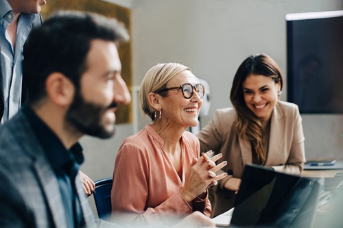 En ældre kollega sidder med sine kolleger