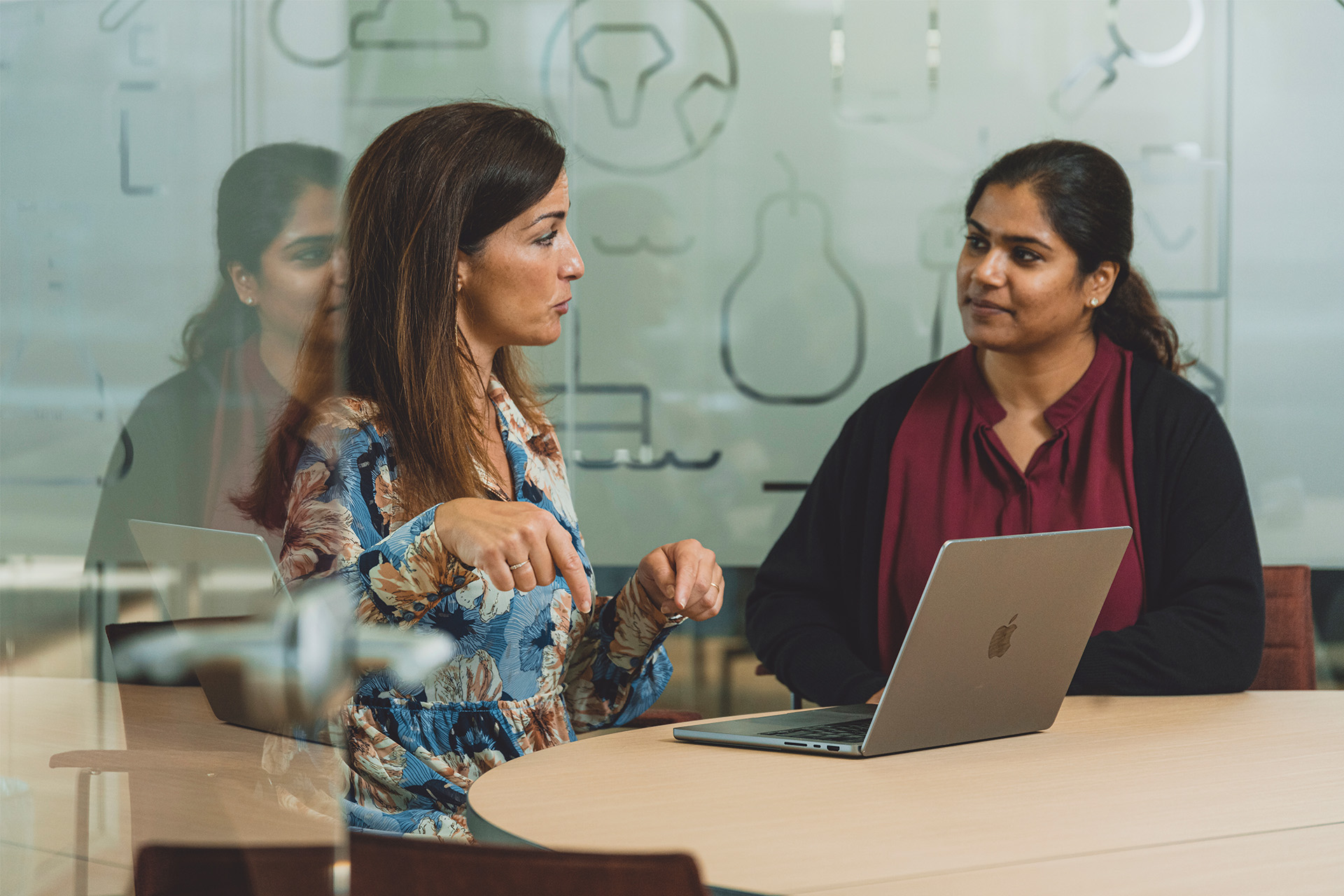 Figen Cayan sidder og snakker med en medarbejder