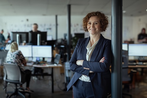 Gitte Kirkegaard står i midten af kontoret