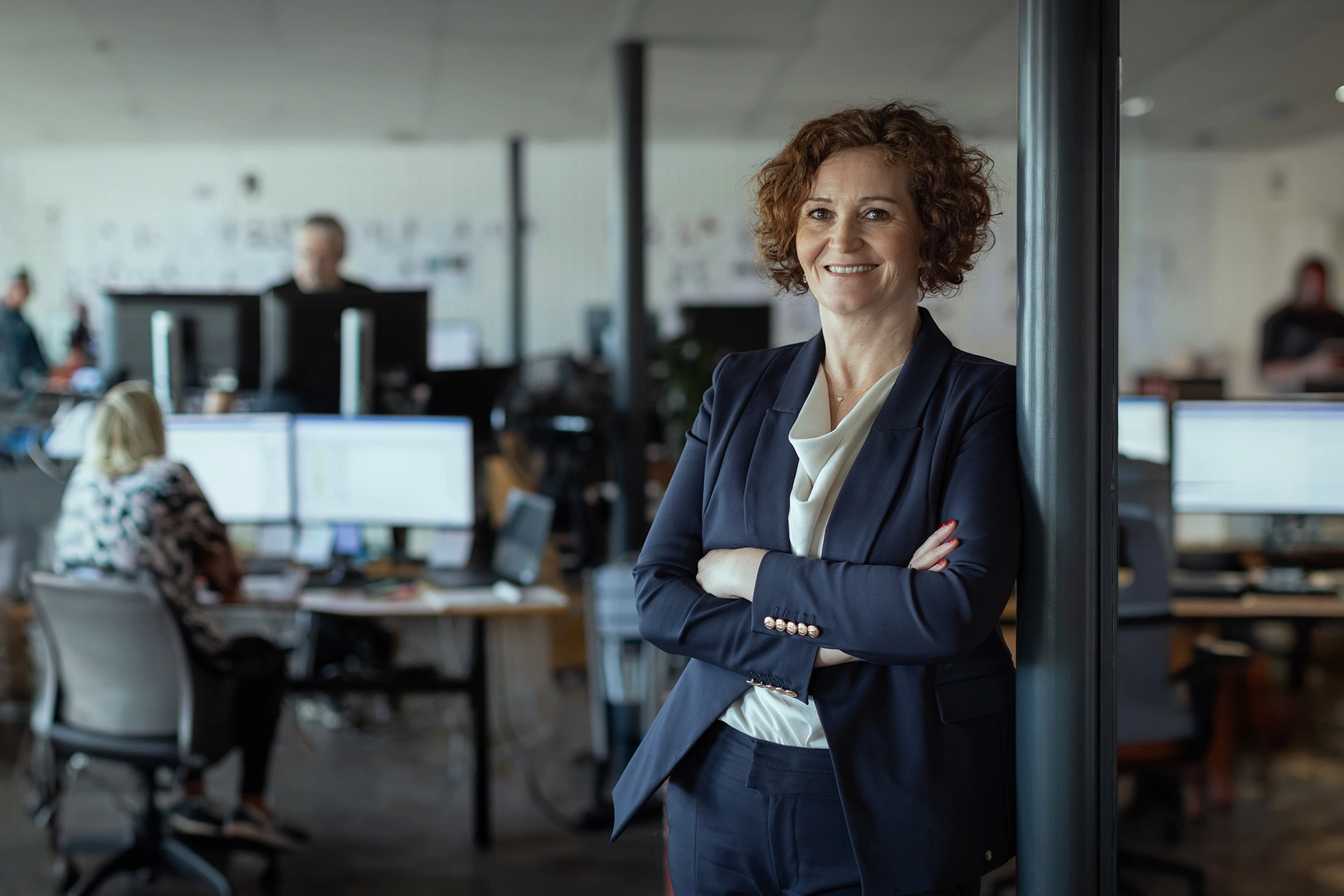 Gitte Kirkegaard står i midten af kontoret