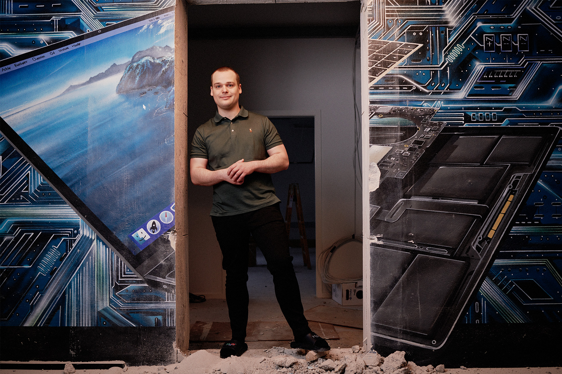 Stifter og ejer af Glad Teknik Mathias Nielsen står i en døråbning iført badesandaler