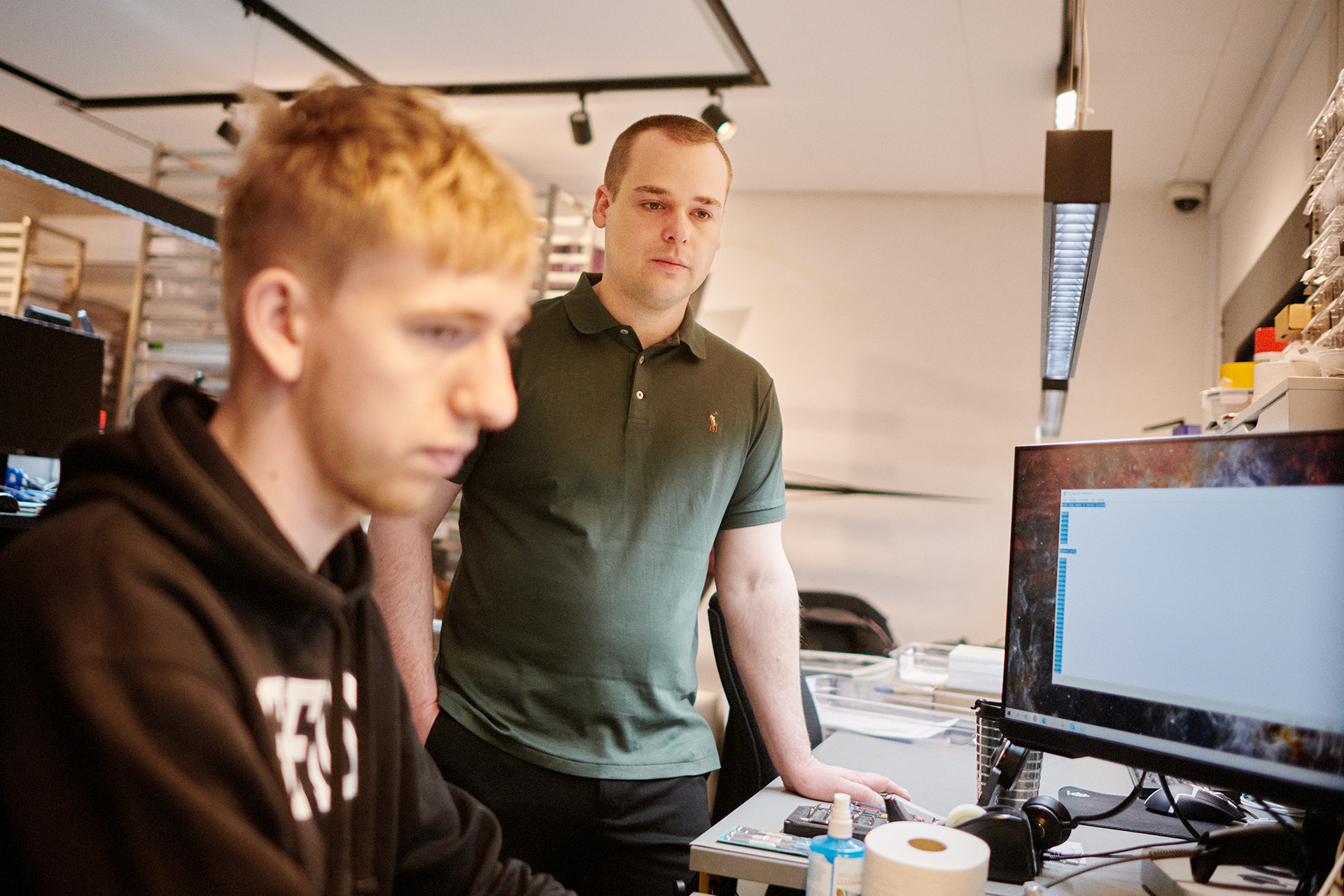 Stifter og ejer af Glad Teknik Mathias Nielsen ser på en computer sammen med en ansat