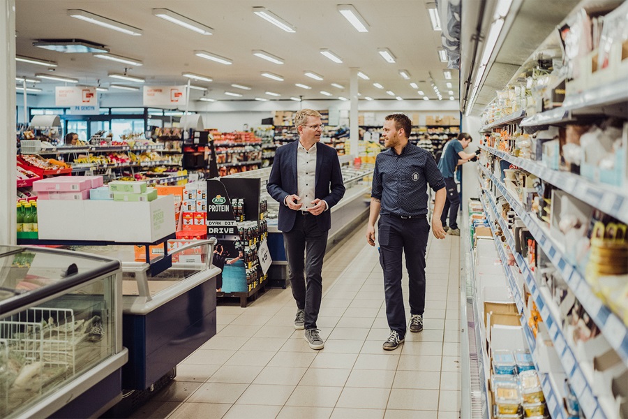 Henrik Burkdal går gennem en REMA 1000 med en medarbejer