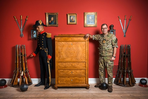 Henrik Rybjerg læner sig op ad en kommode i blandt søfartens historiske genstande