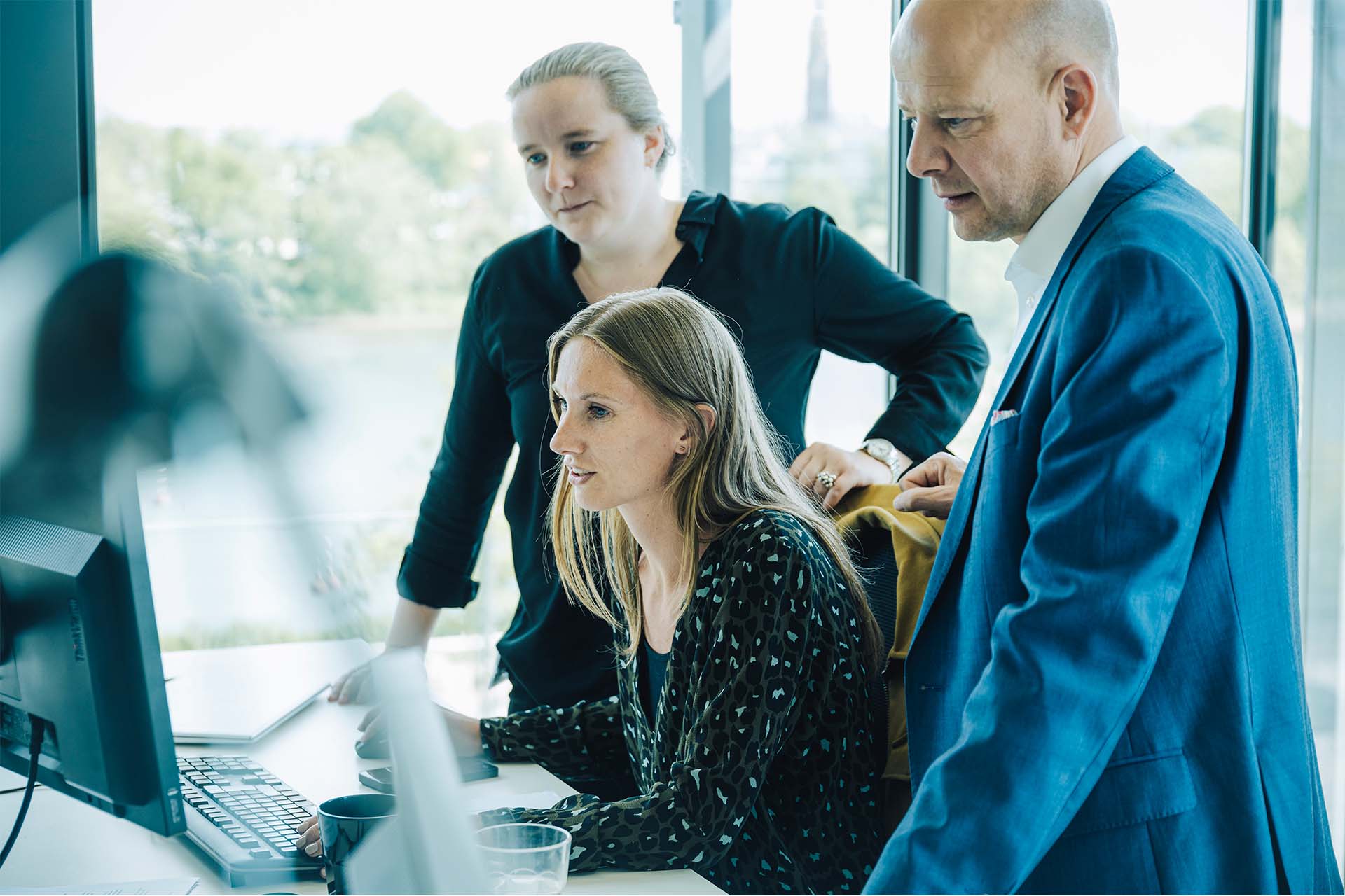 Henrik Wellejus og Emilie Hjort Jensen kigger på en computer med tredje kollega 
