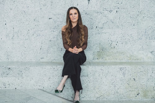 Feminas chefredaktør Isabella Hindkjær sidder på en stenbænk