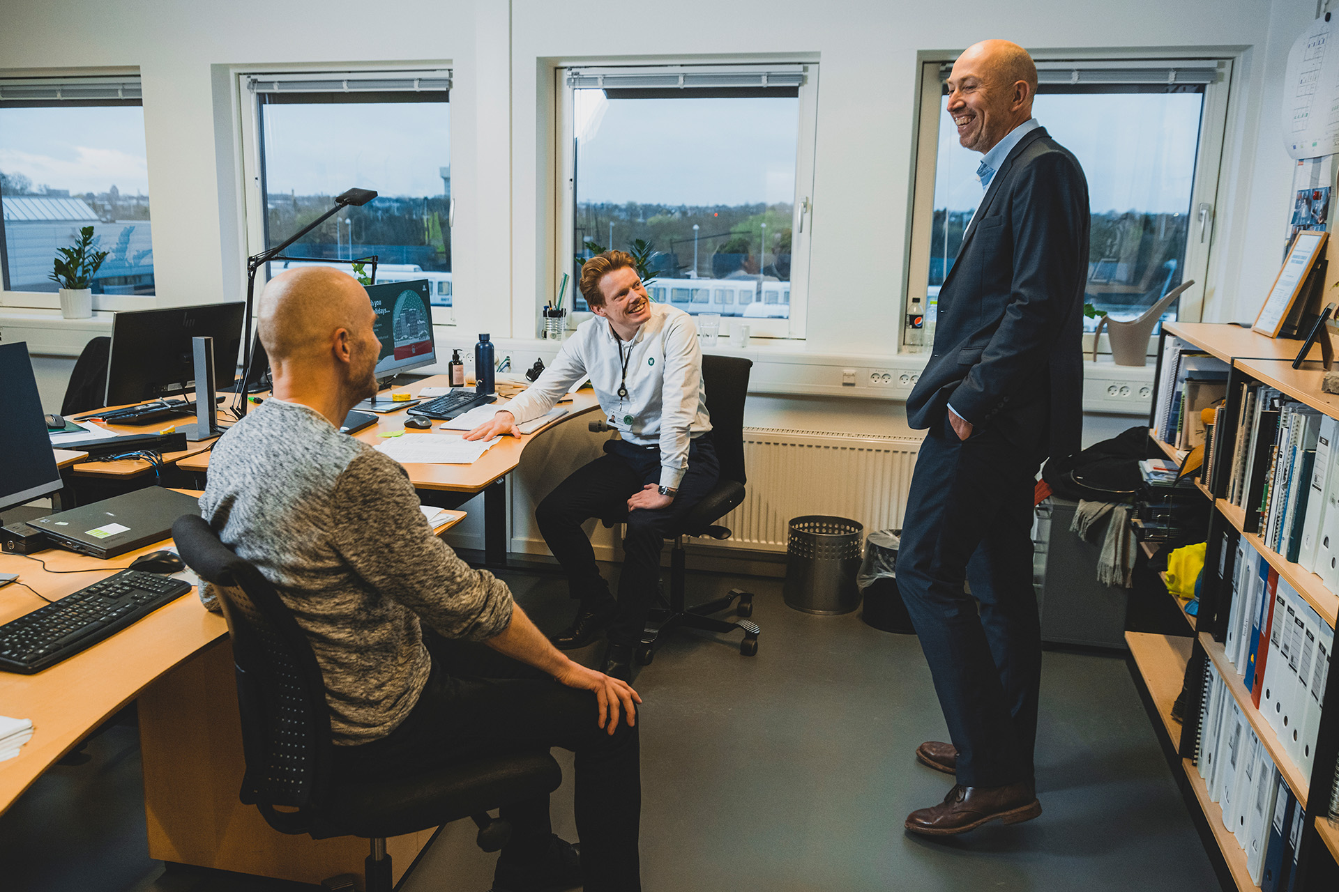 Jakob Keinicke Sørensen står på kontoret og snakker med to medarbejdere