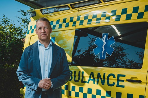Jakob Riis står ved en ambulance