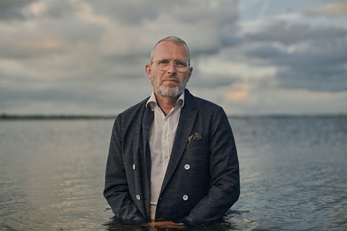 Jan Bybjerg Pedersen står i havet og ser i kameraret
