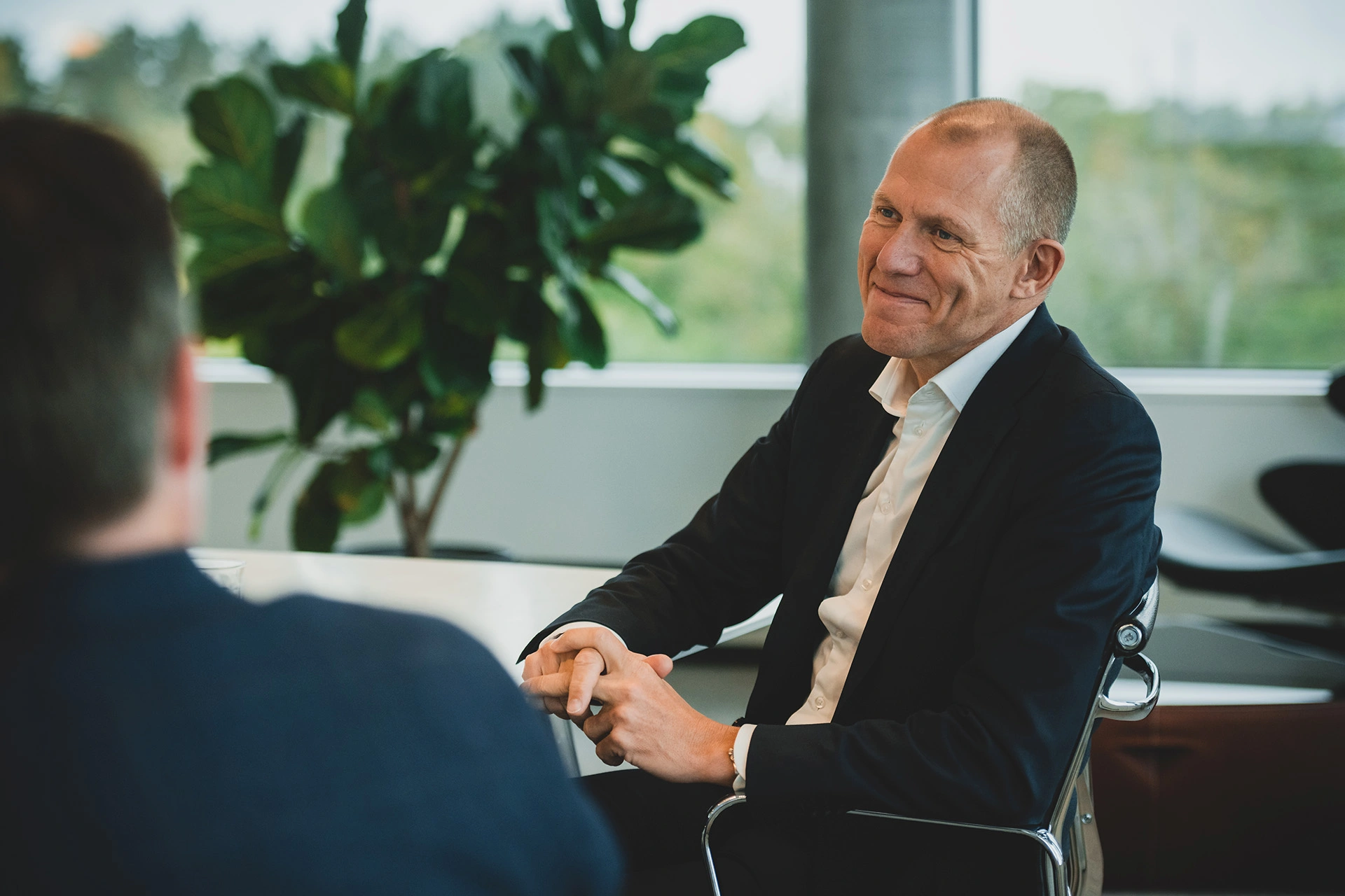Jens Bjørn Andersen sidder og smiler til en kollega