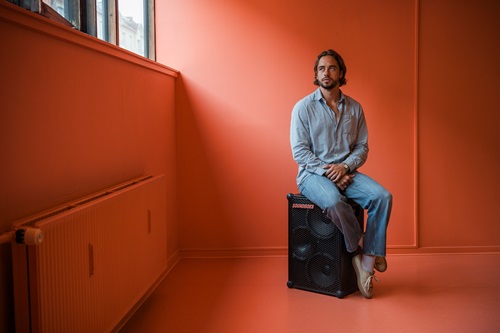 Jesper Thiel Thomsen sidder på en soundboks i et rødt lokale