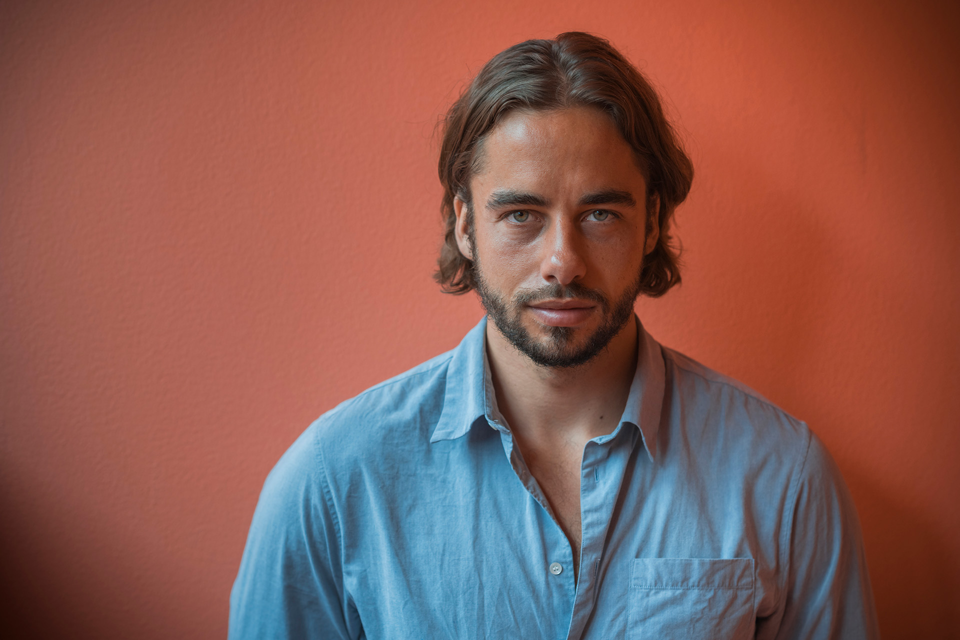 Portrætbillede af Jesper Thiel Thomsen foran rød baggrund