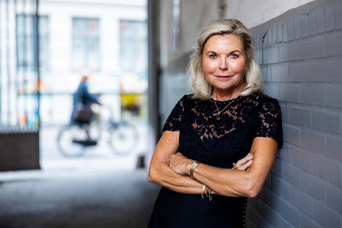 Jette Nygaard-Andersen læner sig op af port udenfor