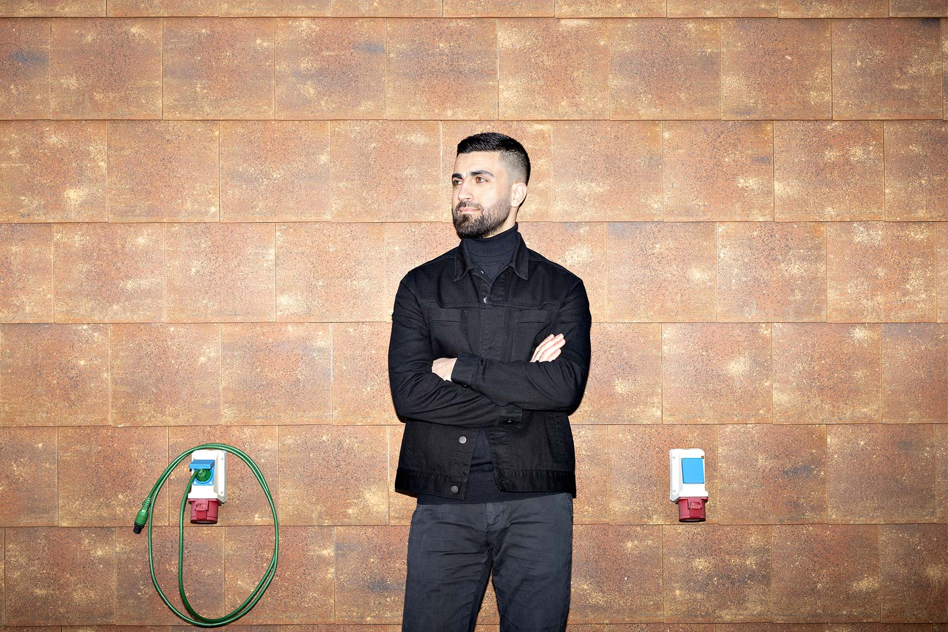 Karvan Shojaeipoor står foran en brun væg